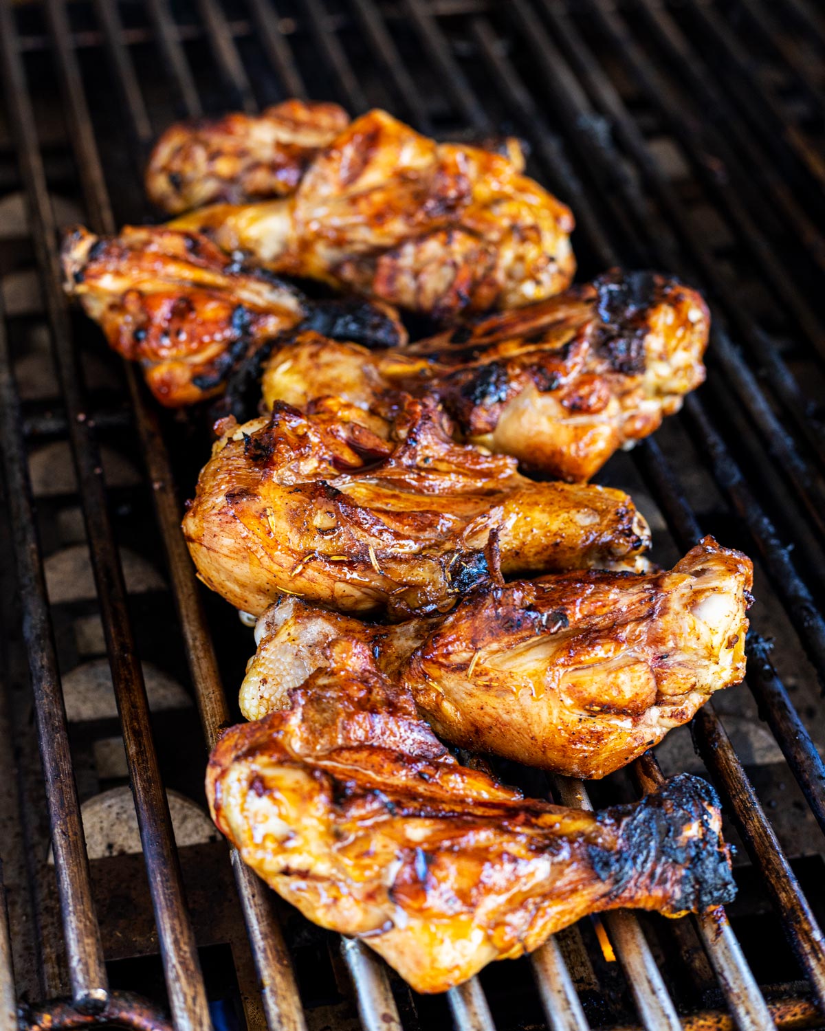 Butterflied chicken drumsticks are almost done grilling.