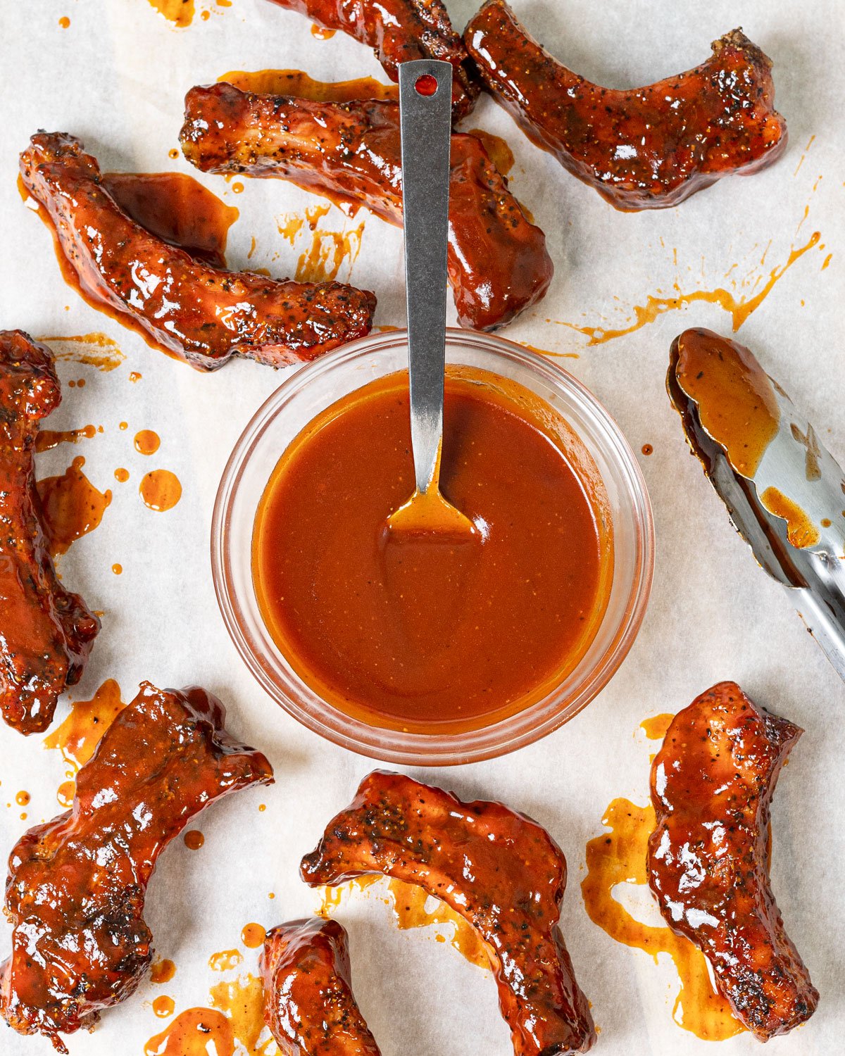 Buffalo barbecue sauce in a bowl with grilled pork ribs.