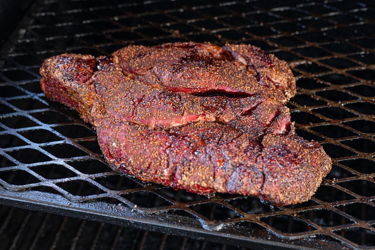 Chuck roast developing bark on smoker grates mid-cook