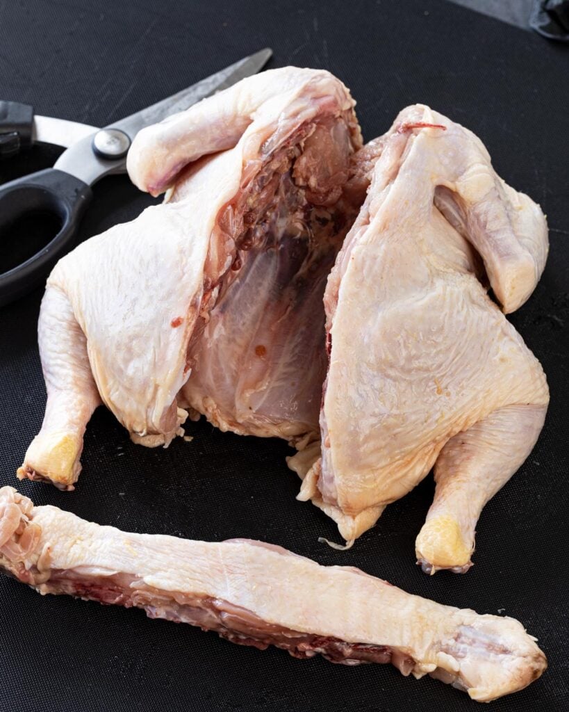 Removed the backbone from the chicken for either splitting or spatchcocking.