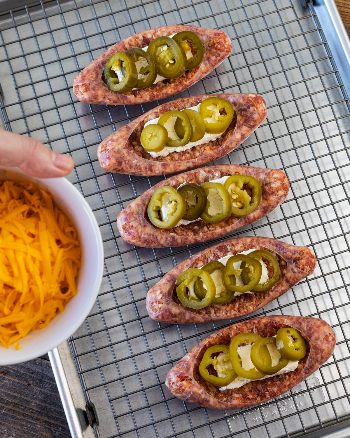 Adding in the cream cheese, pickled jalapenos, and cheddar to the sausage boats