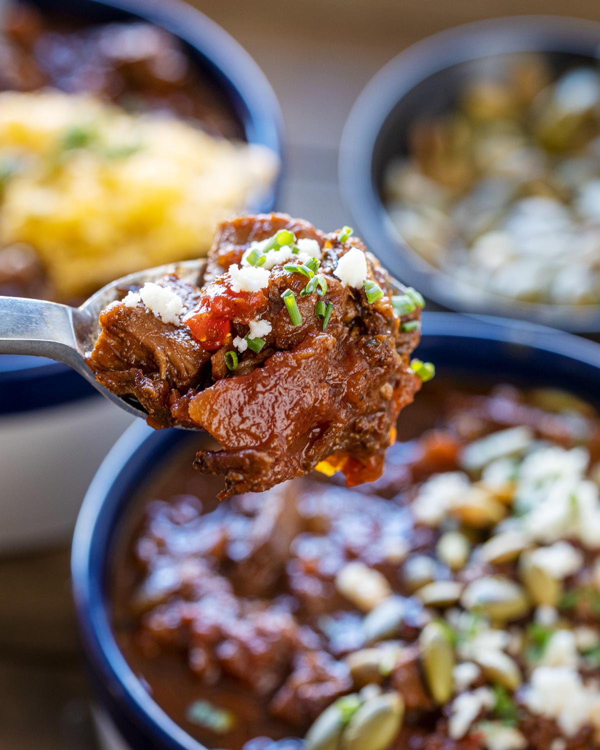 Here's a bite of chili with a big piece of bacon.