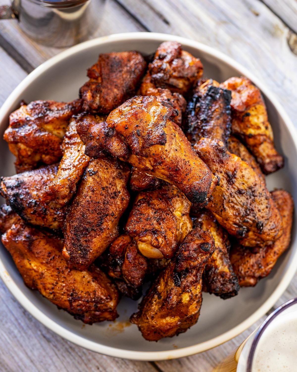 Close overhead view of a bowl of grilled chicken wings with crispy browned skin