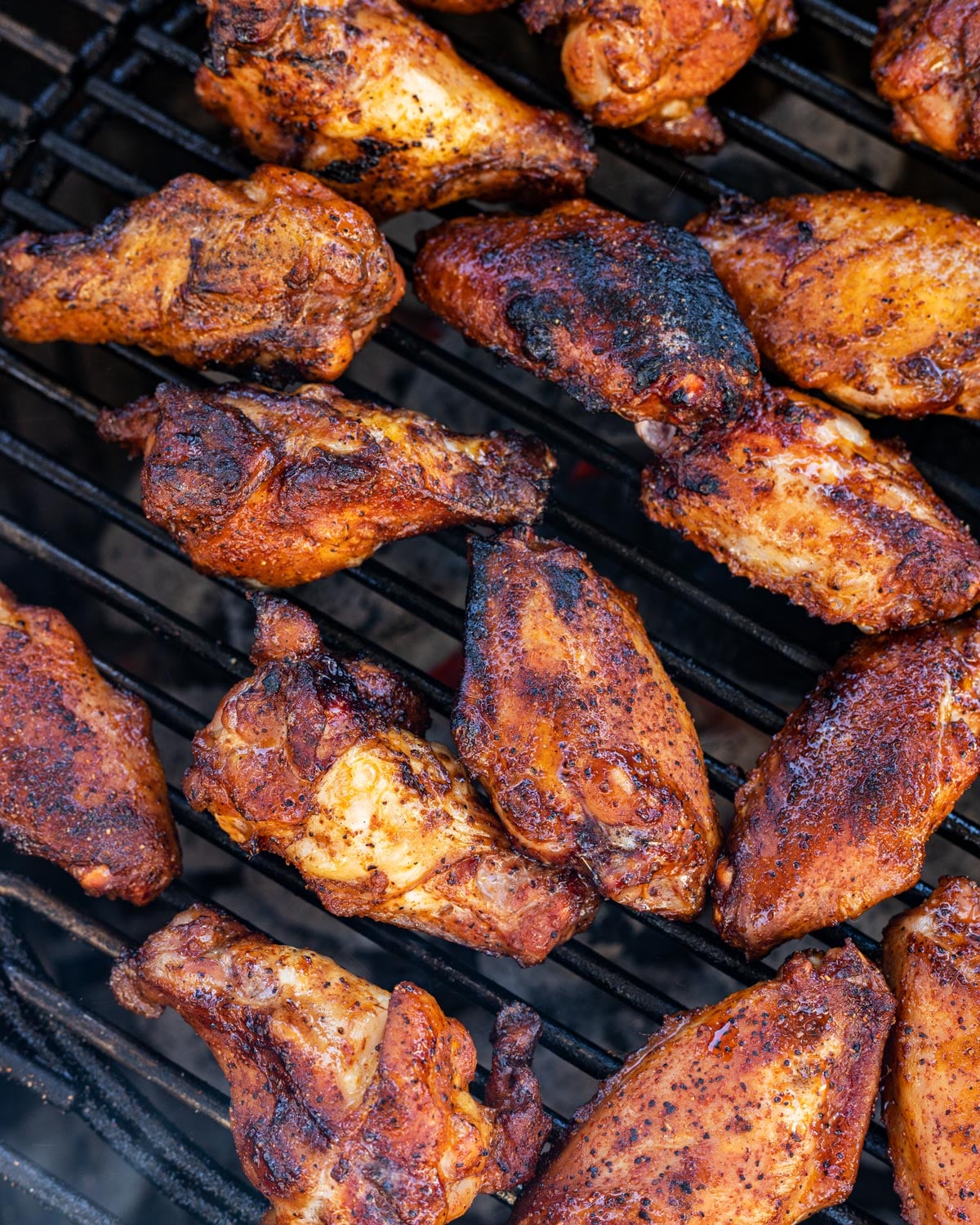 Chicken wings browning on the grill grate during the indirect cook