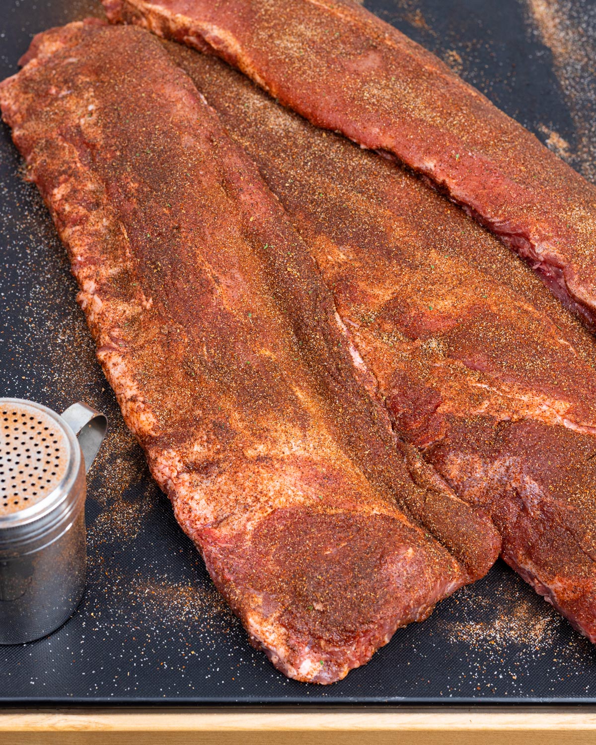 Season the baby back ribs generously with the Cajun seasoning.