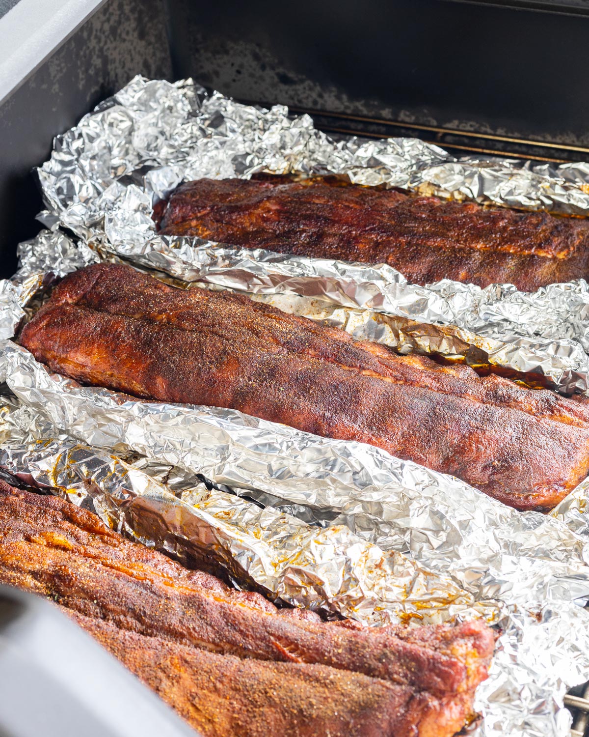 Open up the ribs and flip them, so they can finish in the smoker and re-set the bark.