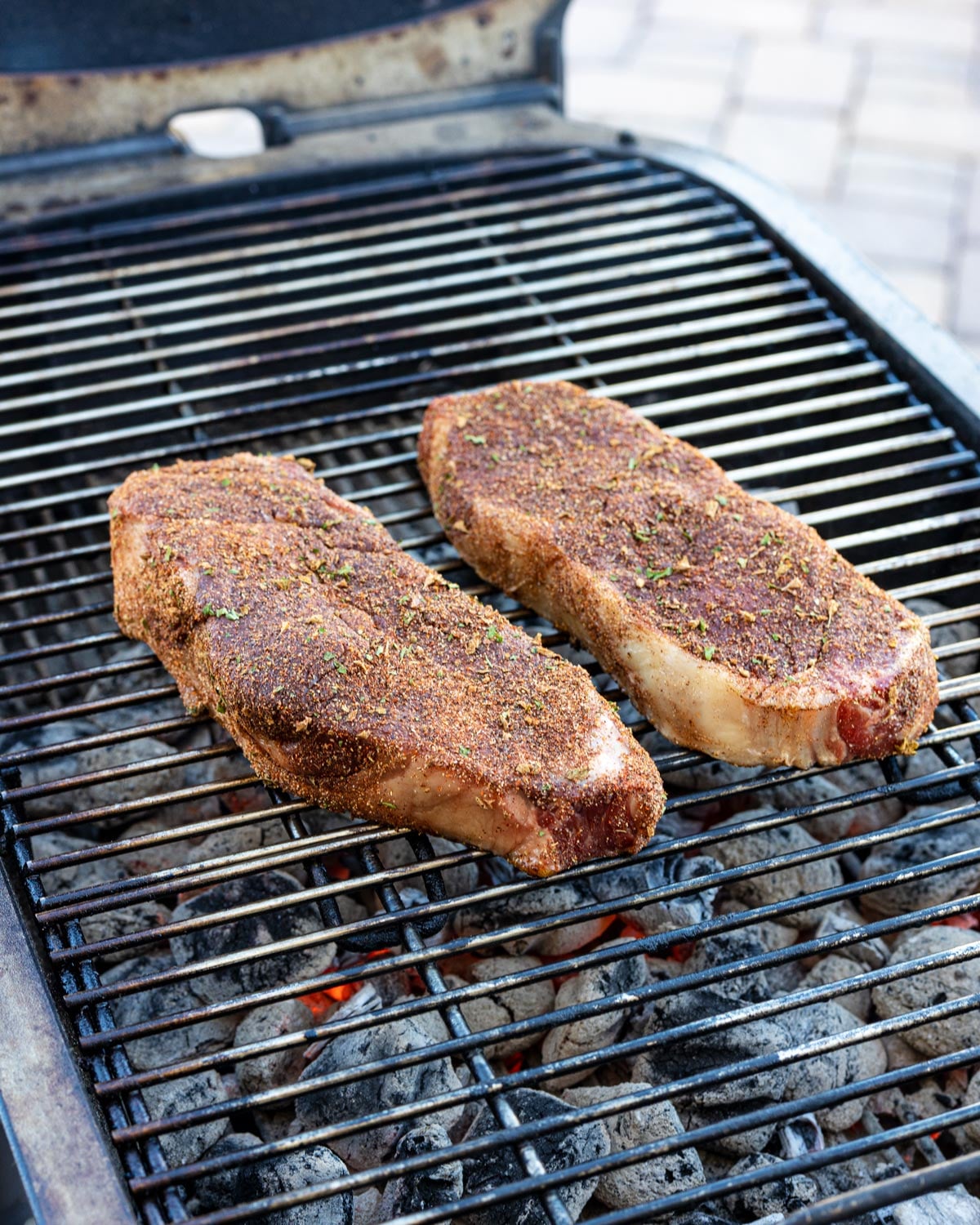 Sear the steaks directly over the coals while regularly flipping to control the temperature.