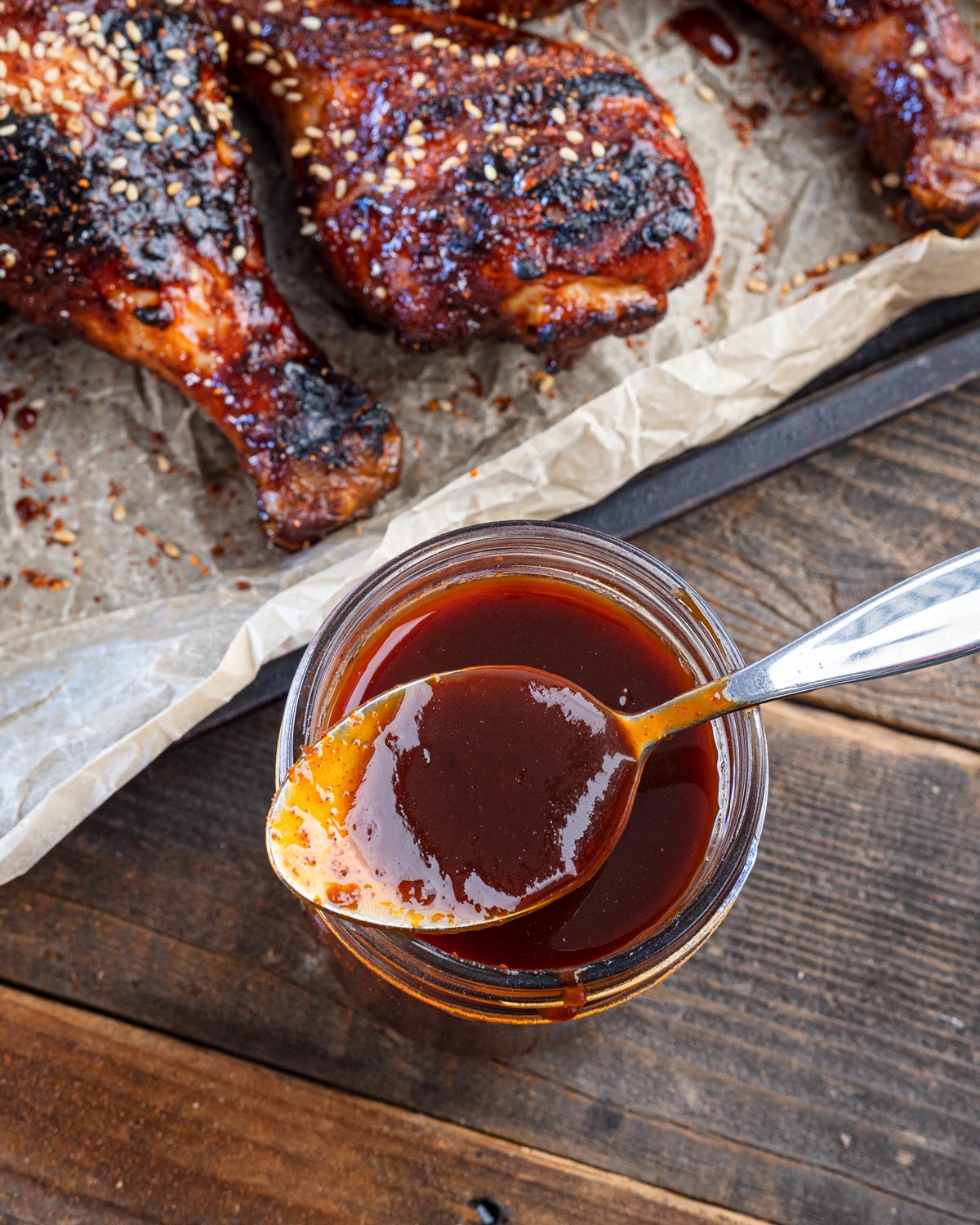 Spoonful of glossy Korean BBQ sauce lifted from a jar to show its thick coat