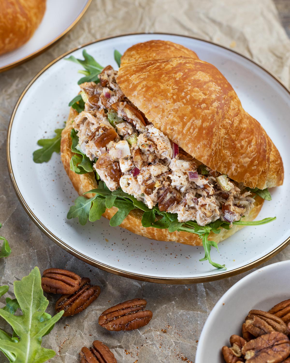 Smoked chicken pecan salad served with arugula on a croissant.