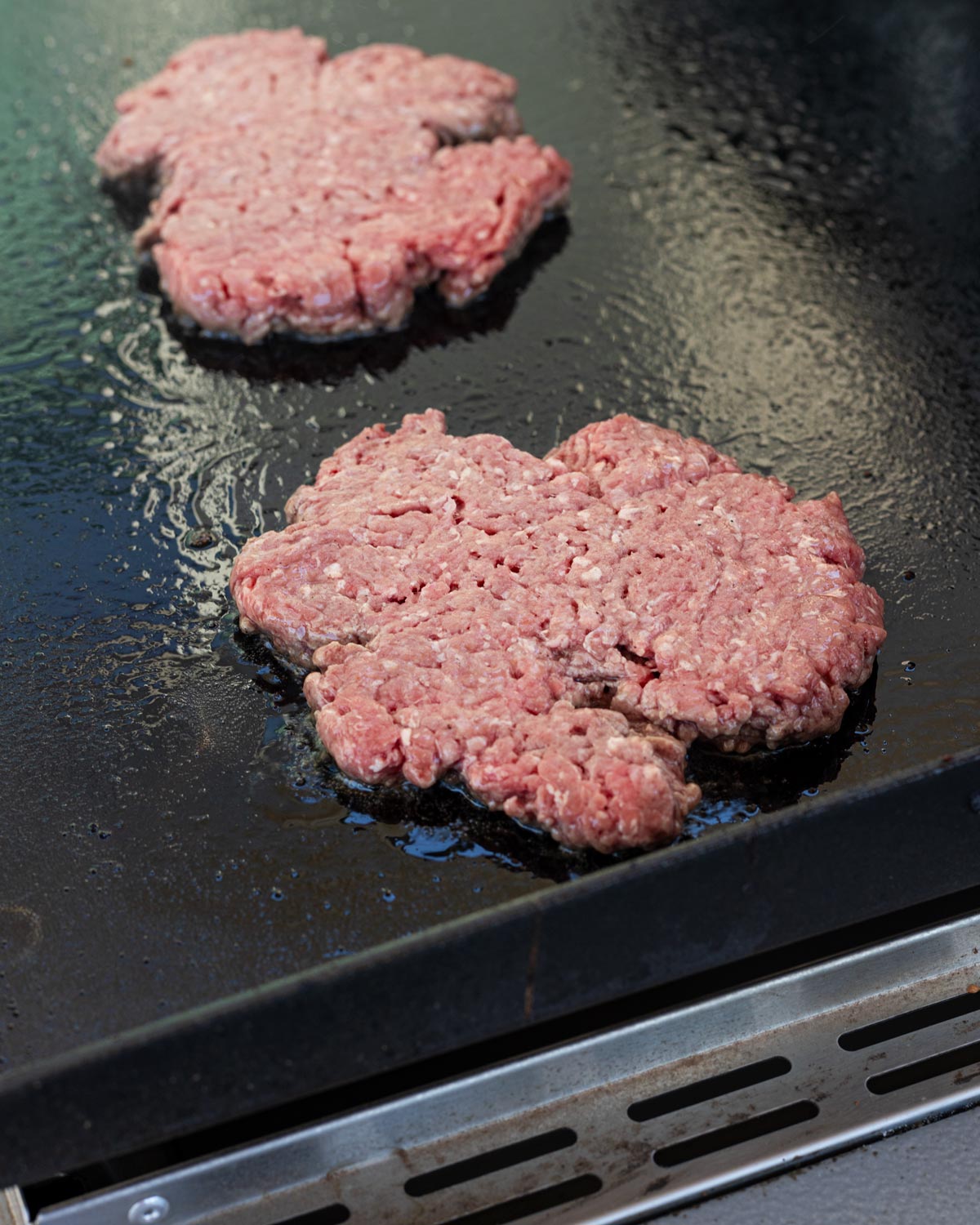 Sear the beef on the hot griddle to build a crispy crust.