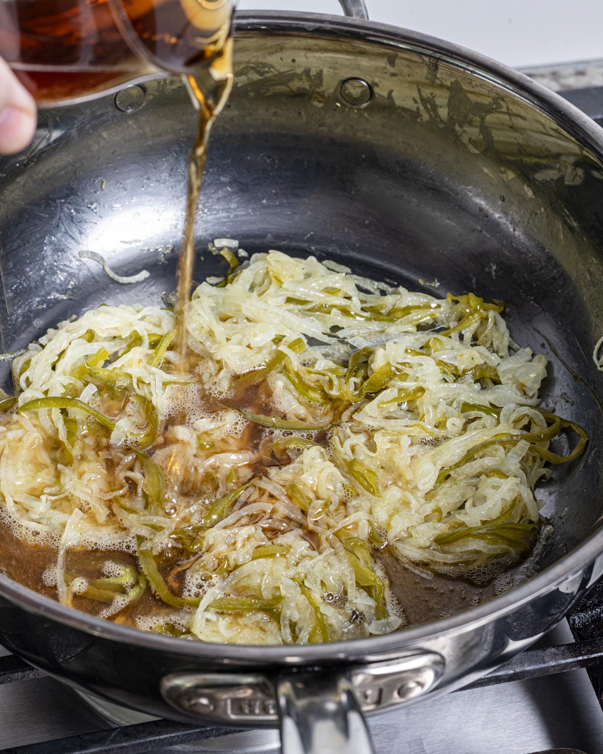 After about an hour of caramelizing, slowly add in a bit of beer to deglaze the pan.