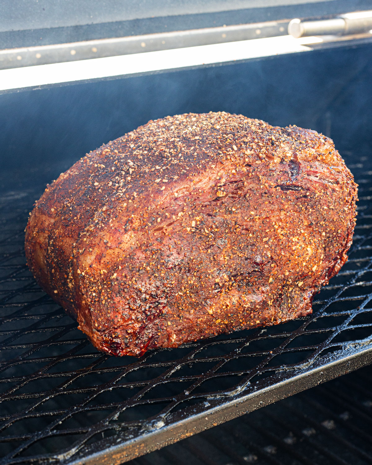 prime rib roast smoking on the grill, crust further developed