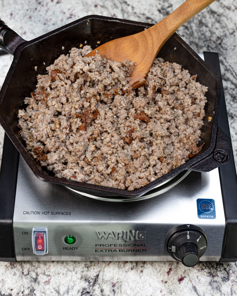Sear the seasoned sausage first in the skillet.