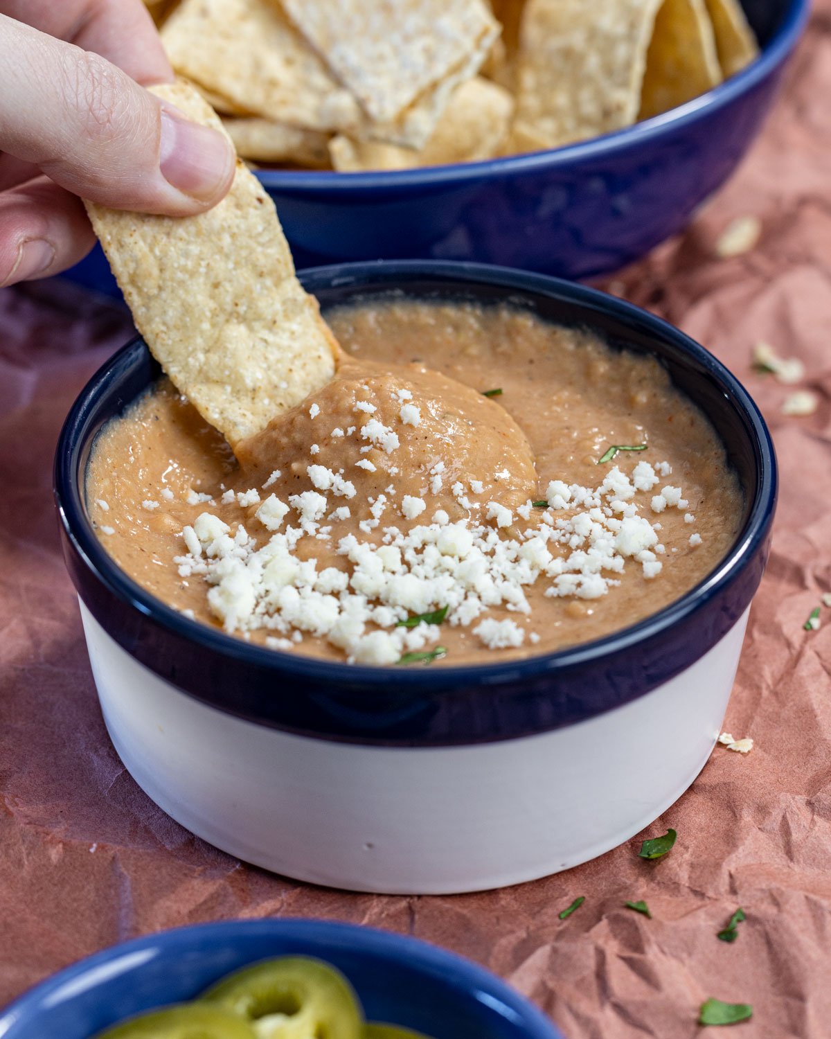 Dipping a chip into creamy pinto bean dip.