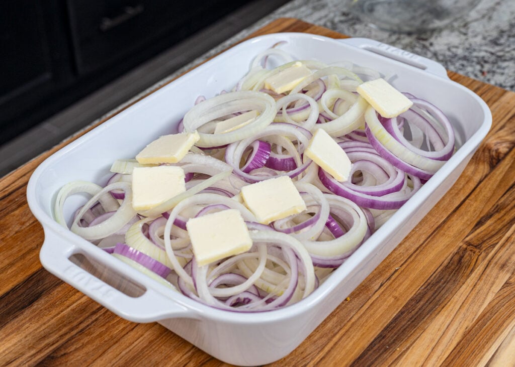 Add the butter to the separated onions in the baking dish.