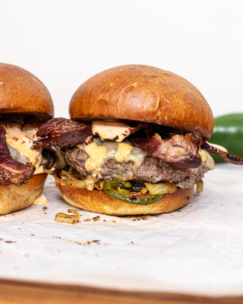 This is a loaded Spicy Southwest burger with bacon, cheese, peppers, and onions.