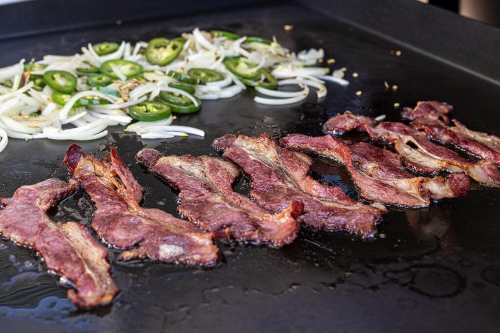 Grilling up beef bacon, jalapenos, and sweet onions.