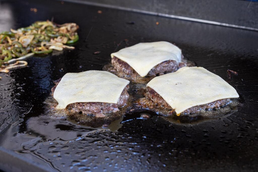 Sear the burgers and top with white cheddar.