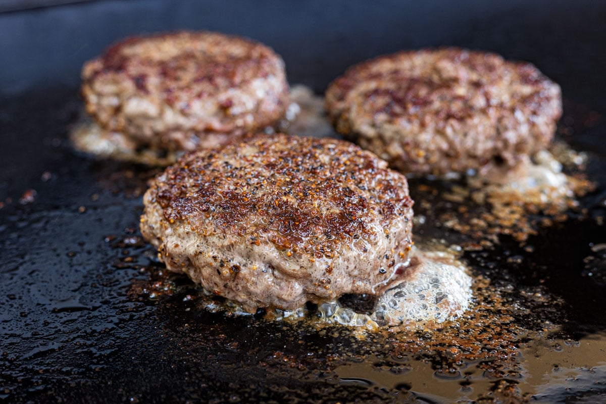 Sear the burgers on the griddle after cooking the bacon and onions.