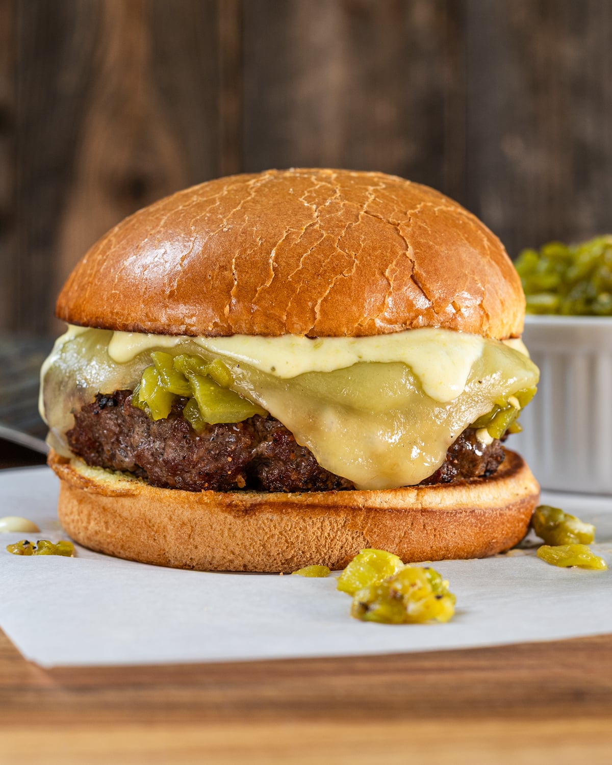 burger patty topped with roasted Hatch chiles and melted white cheese on a toasted brioche bun