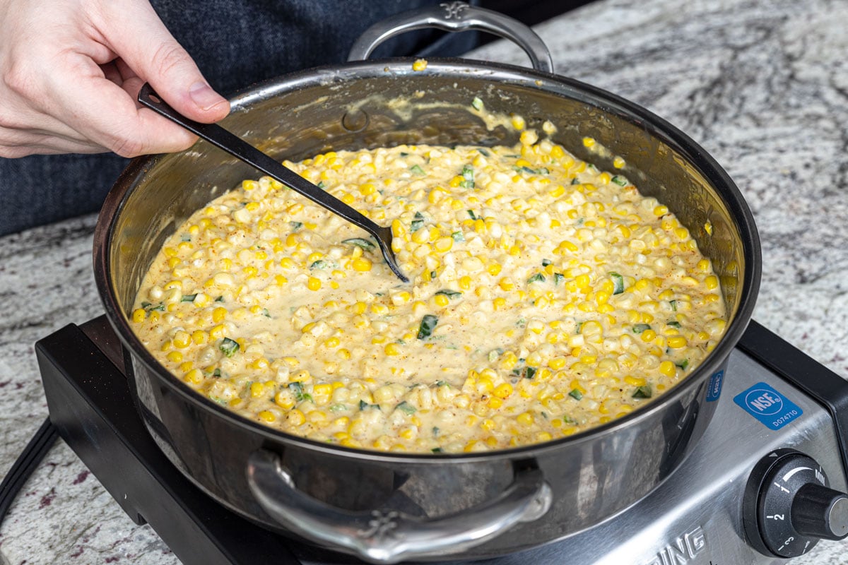 Southwest creamed corn is cooking on low heat in a sauce pan