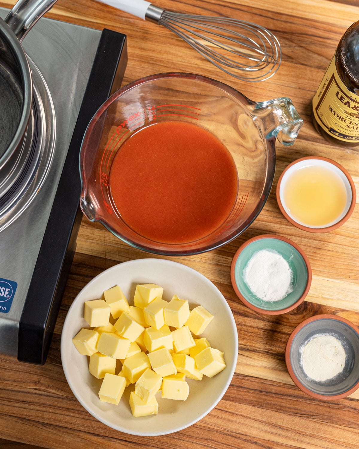 Hot sauce, cubed cold butter, vinegar, and spices laid out before cooking