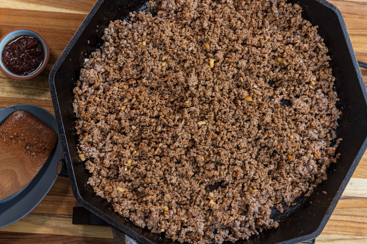 Add the spices and aromatics to the ground beef once browned