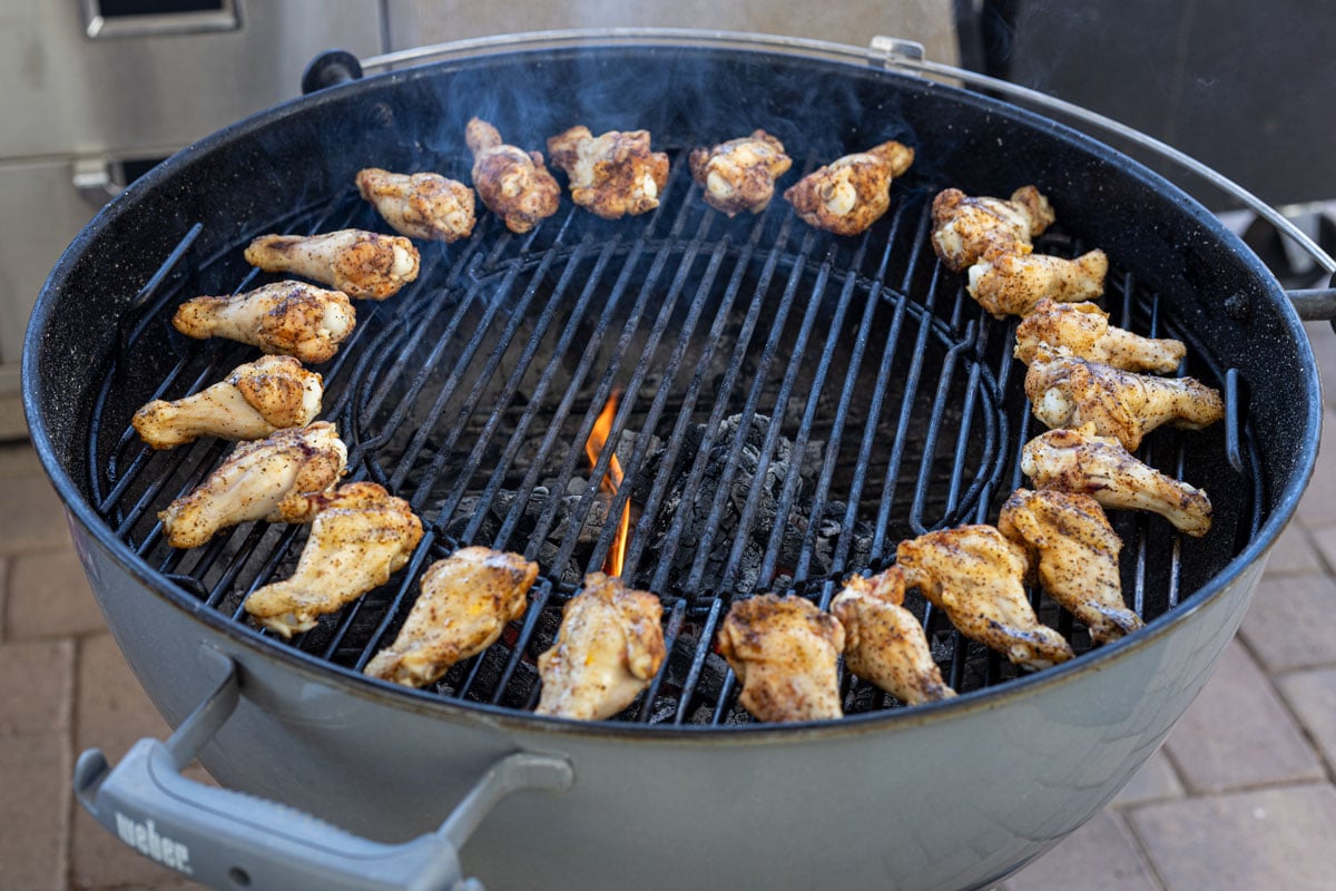 Wings being grilled on the outer layer of the grill to cook over indirect heat.