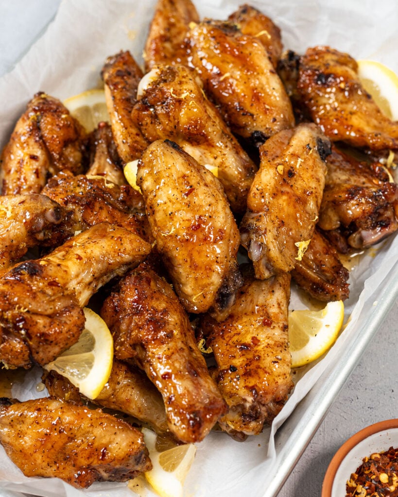 Lemon pepper wings served on parchment paper with extra lemon zest on top.