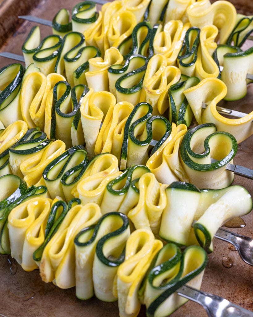 Fresh zucchini and squash ribbons on skewers and coated in lemon oil.