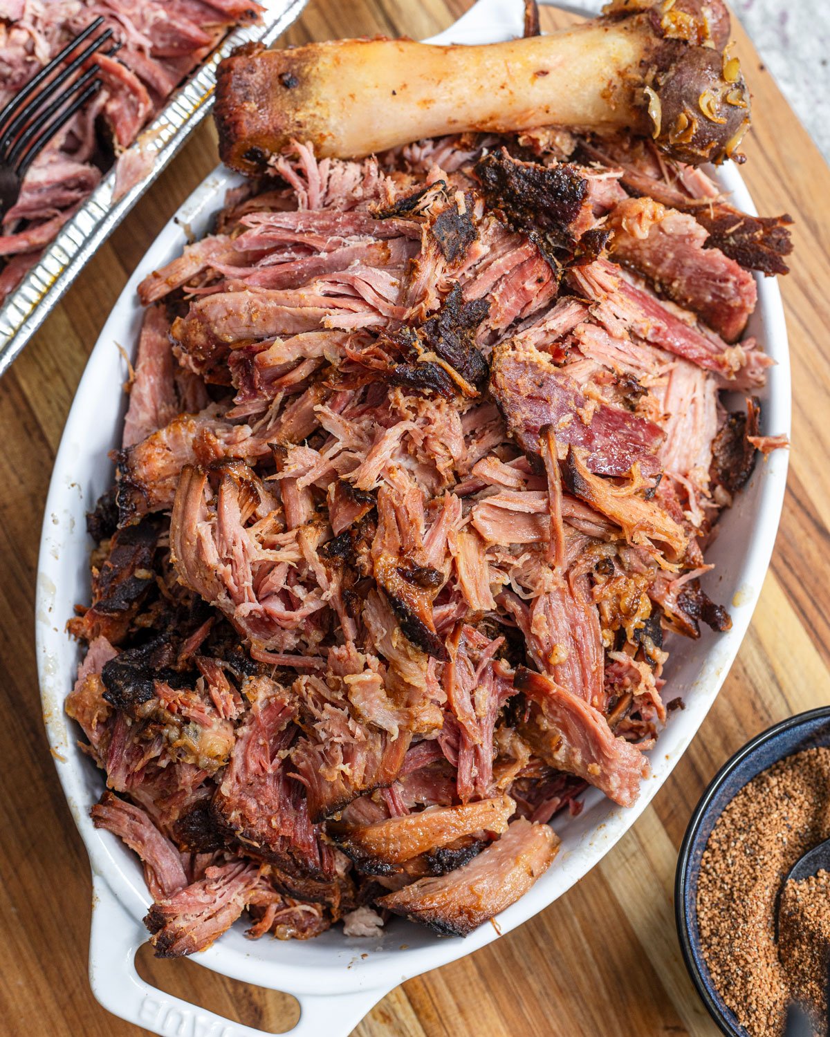 Smoked ham is shredded and in a white casserole dish