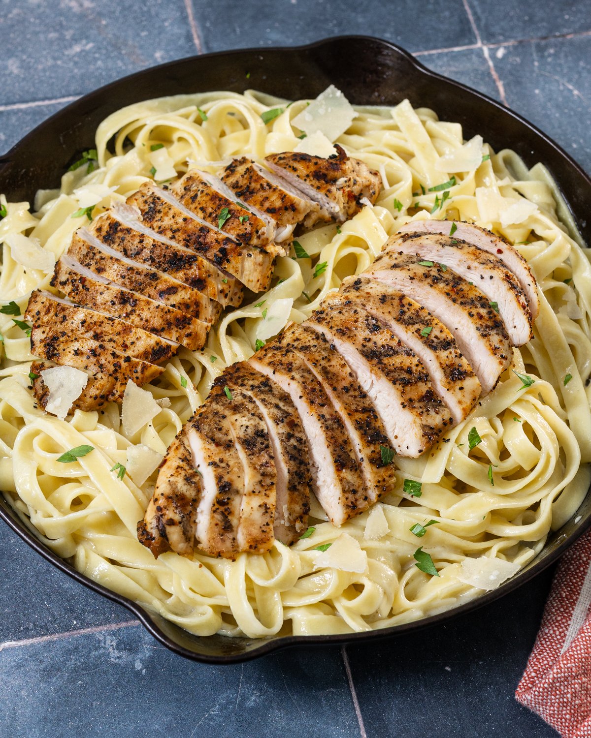 Grilled chicken alfredo, sliced up in a skillet