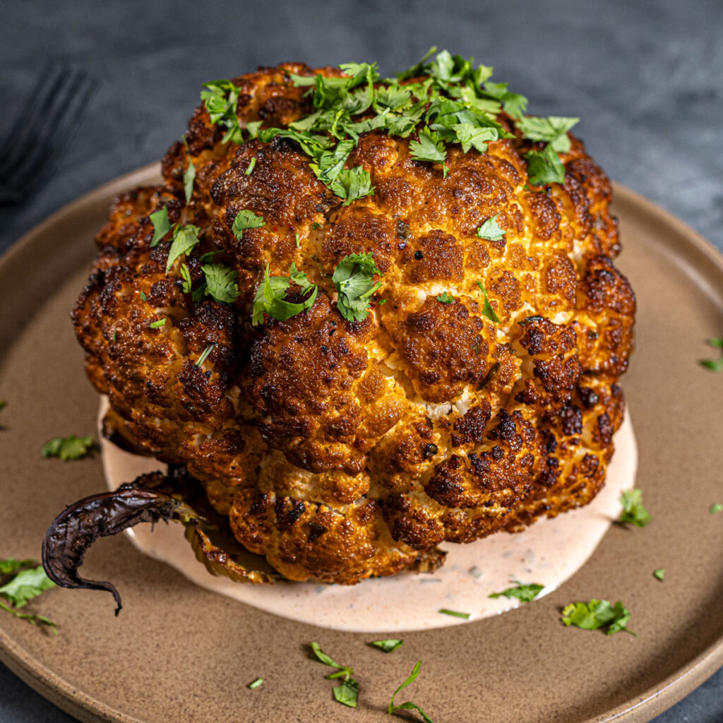 Smoked cauliflower on a plate with herbs and sauce