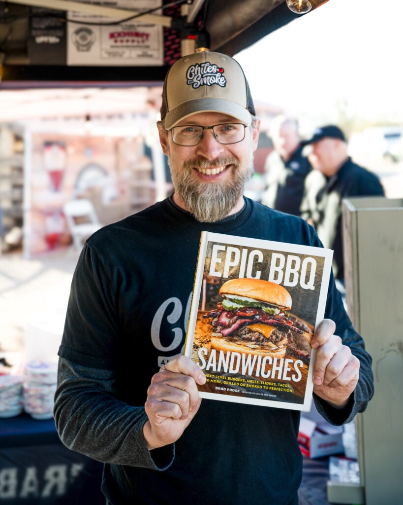 Brad Prose holding Epic BBQ Sandwiches cookbook