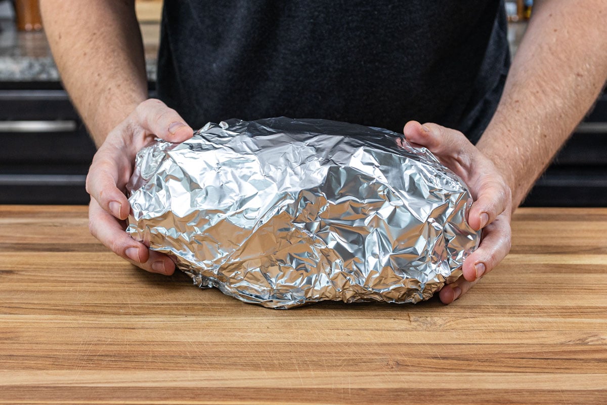 Smoked pork butt double wrapped in heavy duty aluminum foil ready to finish cooking