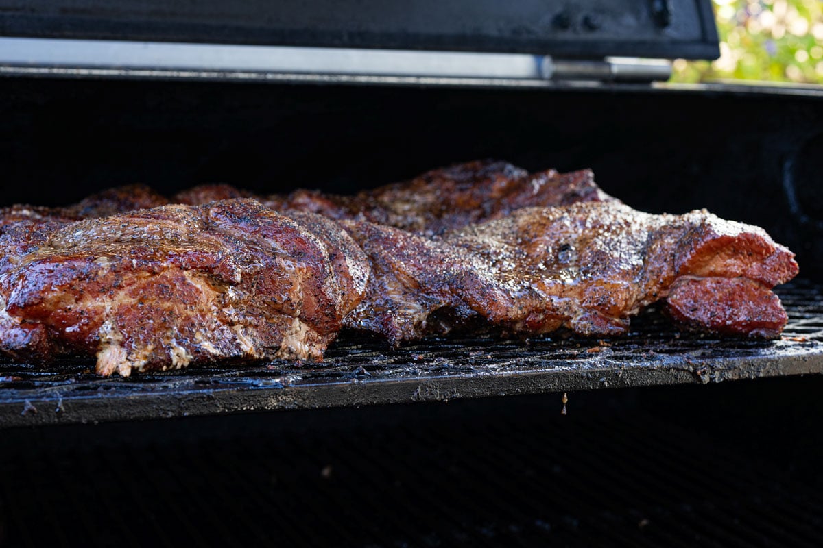 Butterflied pork shoulder with deep dark bark formed after smoking flat at 265°F