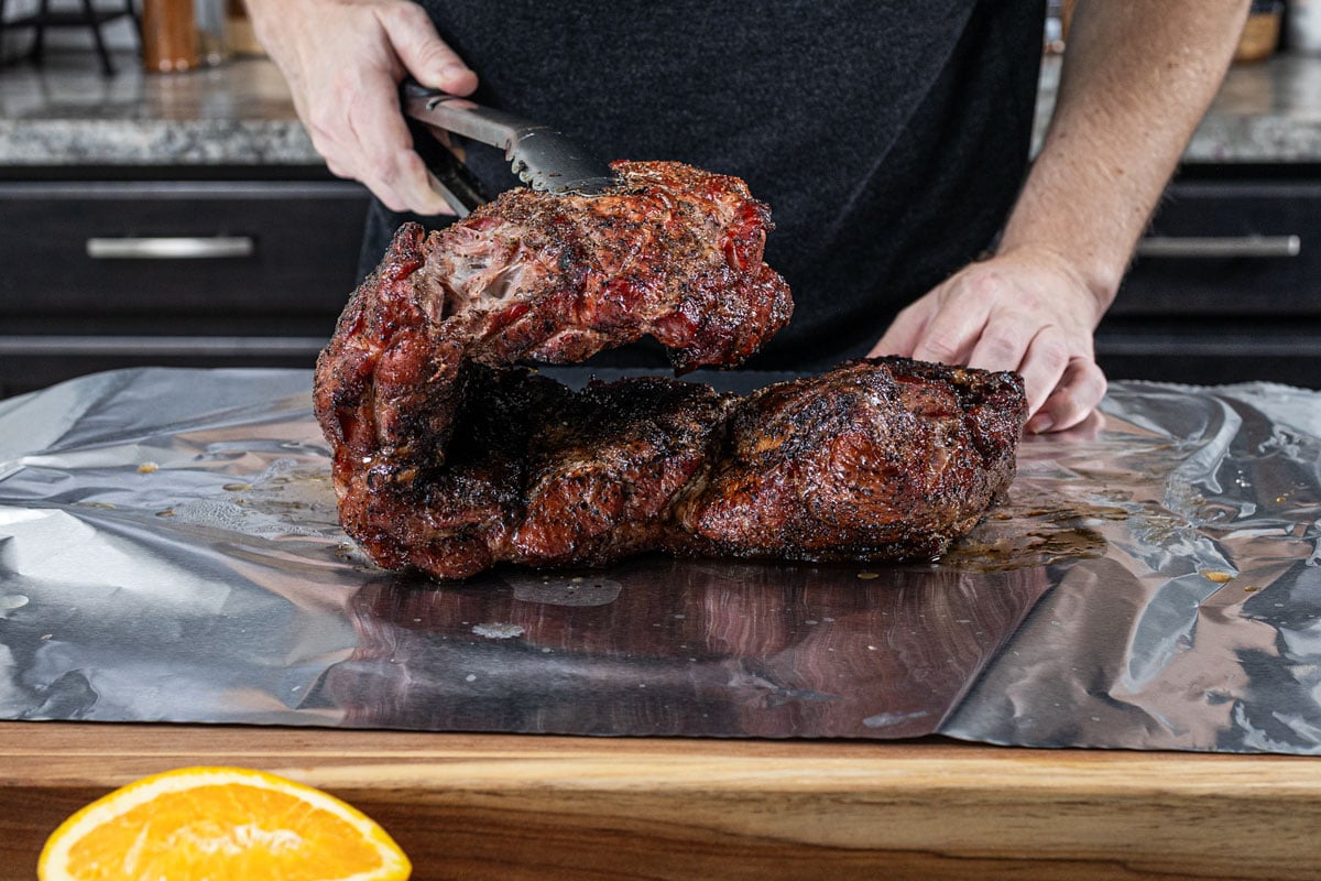 Folding smoked pork shoulder back on itself before double-wrapping in heavy duty foil