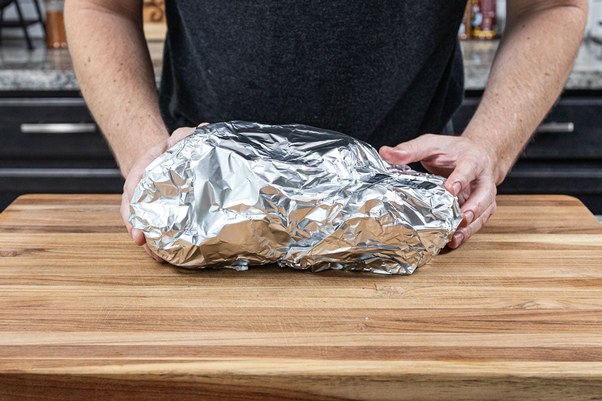 Smoked pork shoulder double-wrapped in heavy duty aluminum foil before finishing cook
