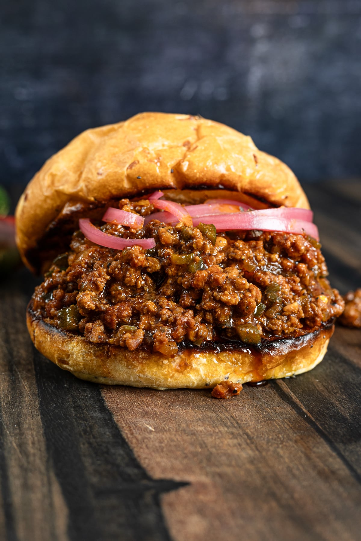 Smoked sloppy joe piled high on a toasted brioche bun with pickled red onions