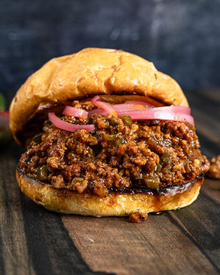 Smoked sloppy joe piled high on a toasted brioche bun with pickled red onions