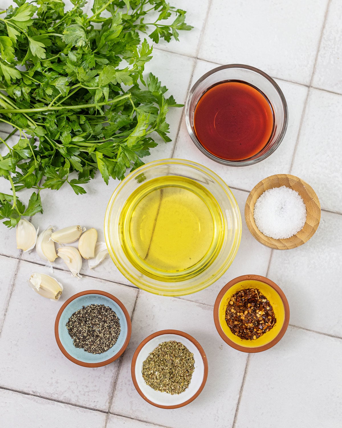 Chimichurri ingredients: parsley, garlic, olive oil, red wine vinegar, oregano, red pepper flakes, and salt
