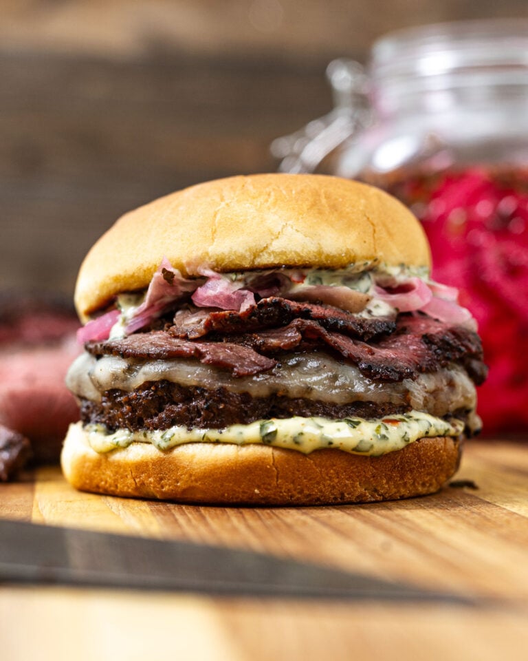 Picanha burger with chimichurri mayo and a jar of pickled red onions behind it