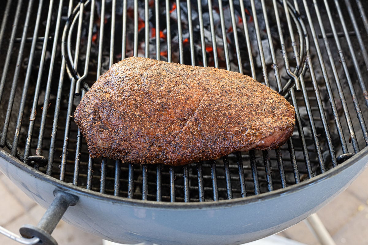 Picanha cooking indirect on a charcoal grill for a reverse sear
