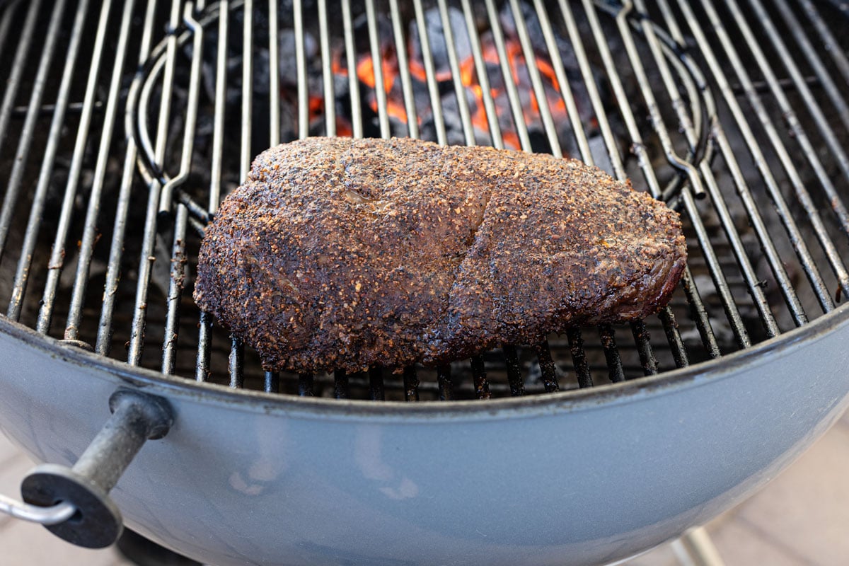 Reverse-seared picanha on the grill grate with flame in the background